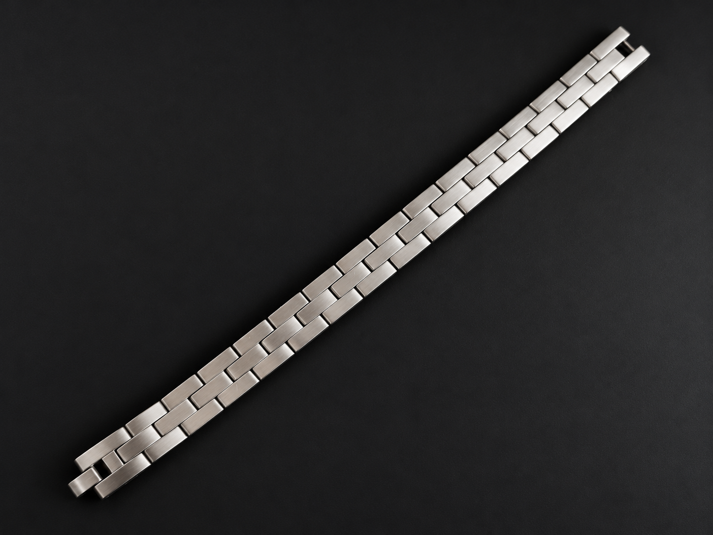 Matt gebürstetes Edelstahl-Armband von ERZSTAHL auf dunklem Hintergrund.
