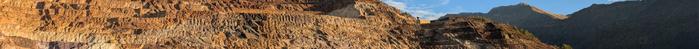 Steirischer Erzberg mit seinen imposanten Abbaustufen im warmen Sonnenlicht – Inspiration für die Schmuckmarke ERZSTAHL.